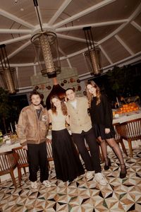 Guests posing under chandeliers at the Four Seasons dinner