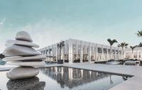 A white resort building reflected in a pool