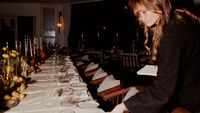 A Zoom Agency team member laying a candlelit table for a press dinner